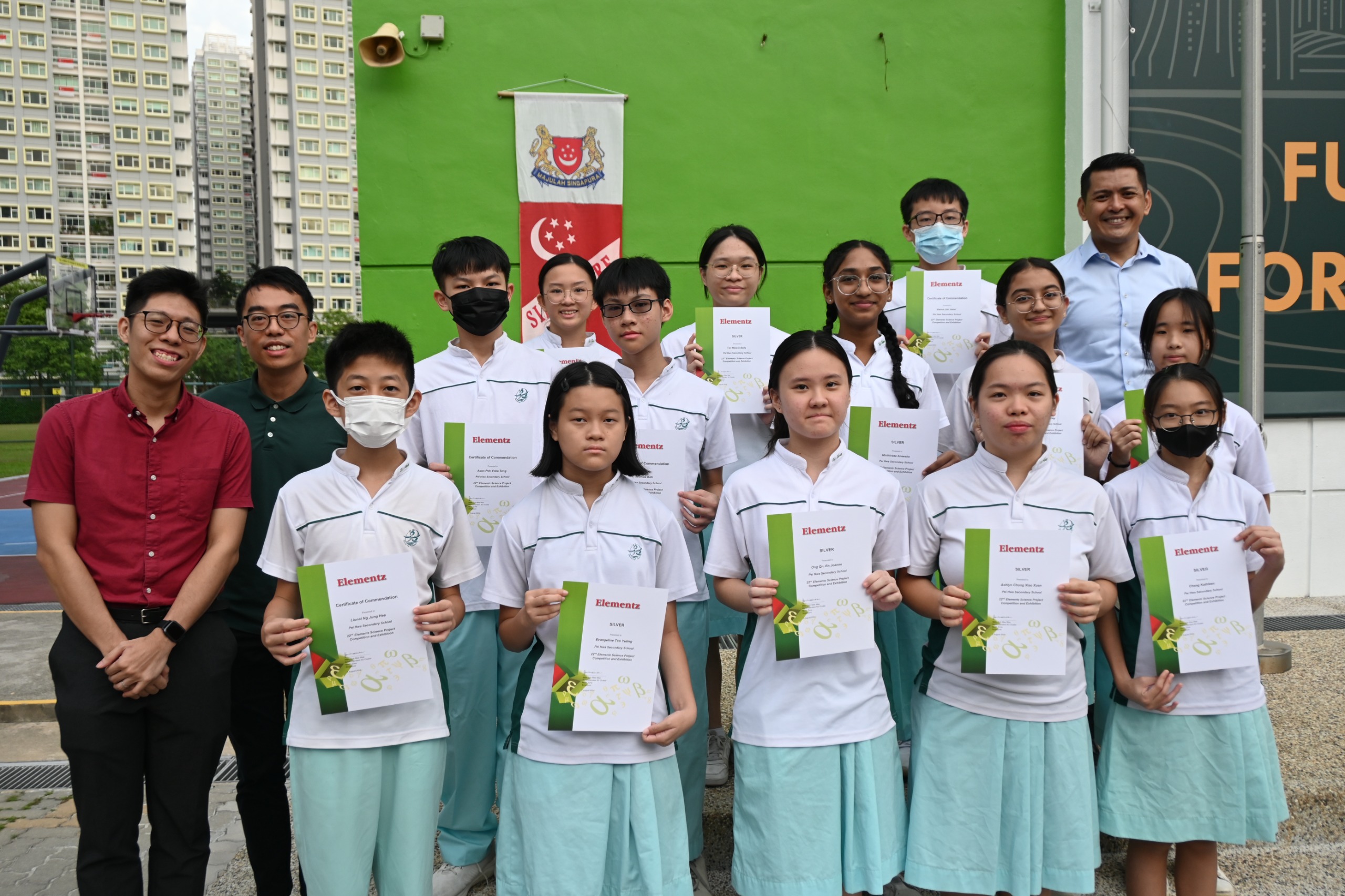 A group of students holding a cert taking photo with 2 teachers as well as the principal
